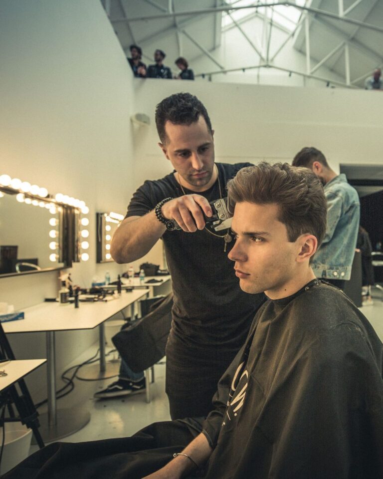 Avalon stylist cutting a man's hair in a backstage studio