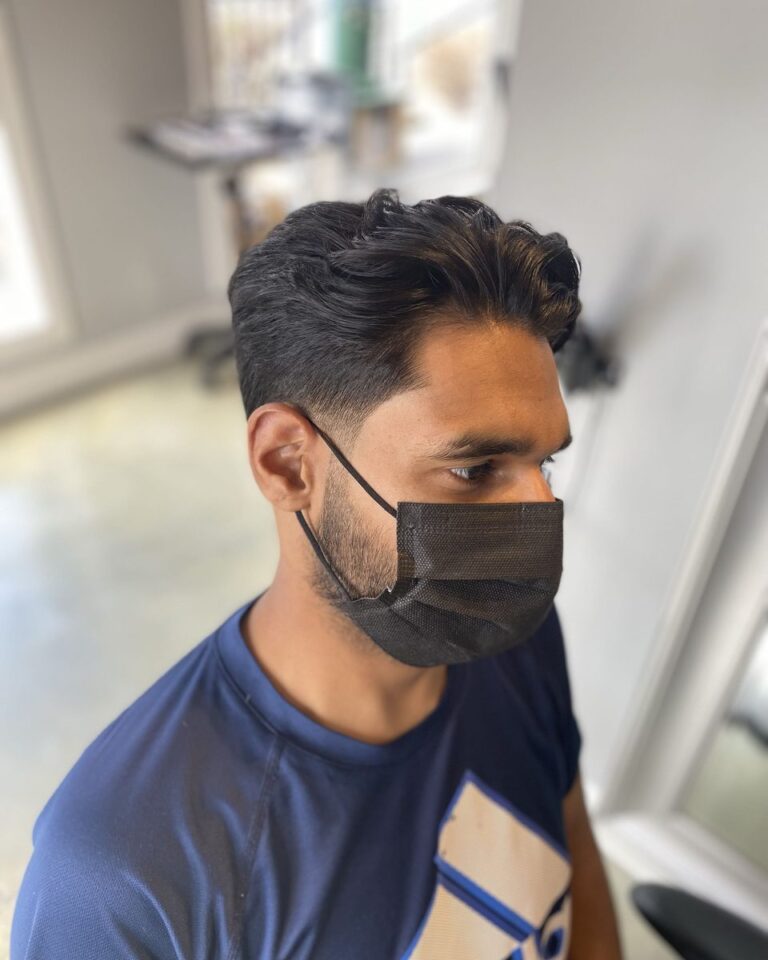 Men's medium-length textured cut swept back, client in a face mask, Avalon Salon Calgary
