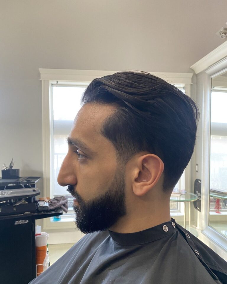 Men's longer slicked-back cut with tapered sides and a trimmed beard, Avalon Salon Calgary