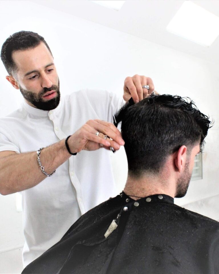 Avalon stylist scissor-cutting a client's thick curly hair